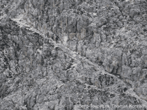 Bergsteiger erklimmen steile Felswand bei Bergtour.