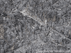 Bergsteiger auf steilem Felsen beim Klettern in den Bergen.