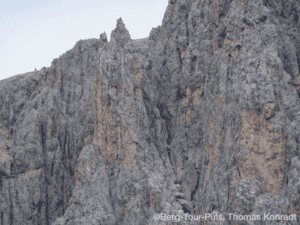 Bergsteiger auf steiler Felswand in den Bergen.