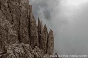 Felsformation bei Bergtour-Puls mit dramatischem Himmel im Hintergrund.