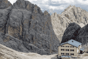 Bergsteigerhaus in den Dolomiten, umgeben von beeindruckenden Felsformationen. Perfekt für Bergtoure.