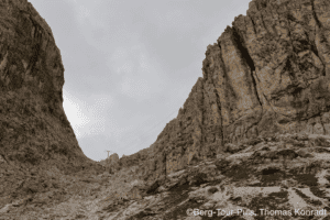Bergtour in einer engen, felsigen Schlucht mit steilen Wänden, ideal für Natur- und Bergliebhaber.