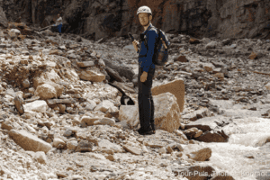 Bergsteiger mit Helm und Rucksack im Geröll bei einer Bergtour.
