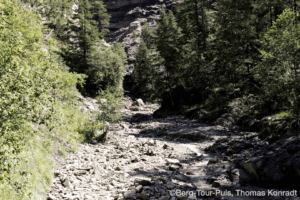 Wanderung durch die alpine Natur mit Fluss und Felsen.
