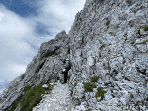 Alpenbergsteiger auf steilem Felsenpfad, Natur- und Bergabenteuer.