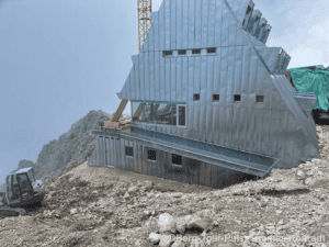 Bergstation aus Metall auf Berggipfel mit Aussicht und Bauarbeiten.