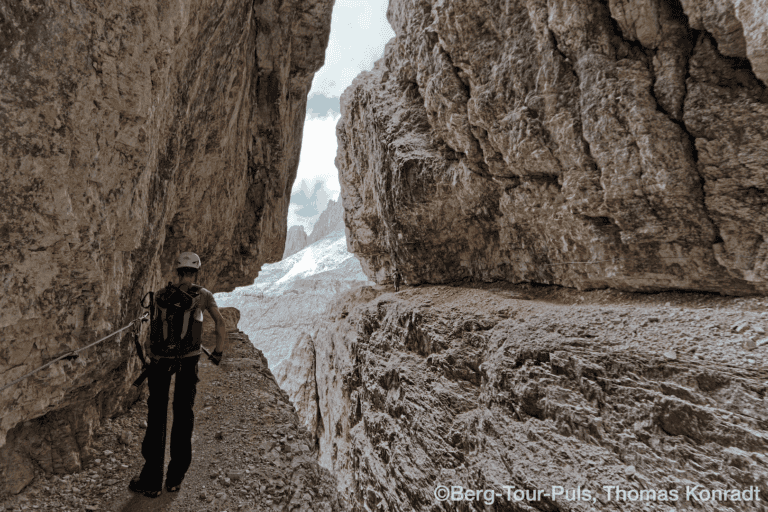 Abseilende Bergsteigerin in einer engen Felsschlucht in den Bergen.